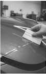 Professional paint protection film installation on an automotive hood
